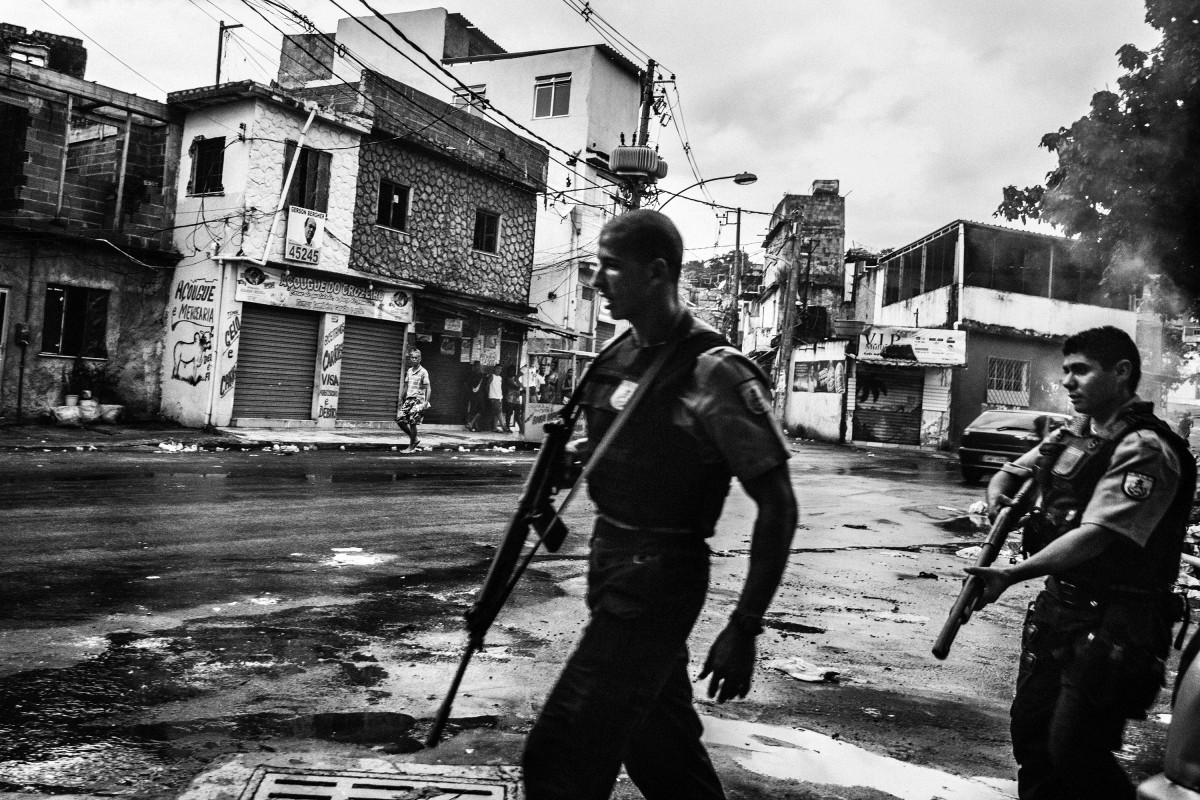 February 2015 - Rio de Janeiro, Brazil: Cops patrolling the streets of Vila Aliança, a favela near Complexo do Alemao. After a militar police cop kill the mototaxi driver Diego da Costa Algavez (22) in the streets of the favela, several cars and high caliber armed cops invaded the streets in alert of a possible confrontation with the gangs and from the population.